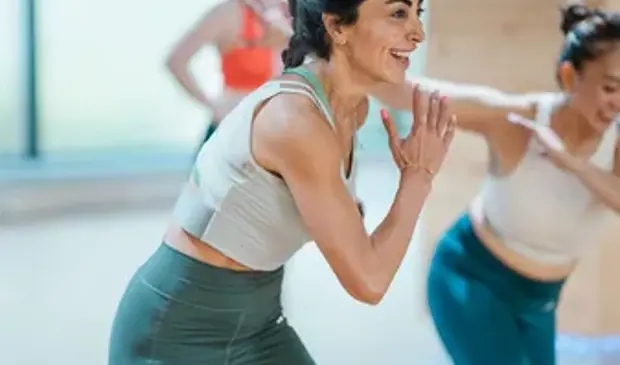 Women warming up during a BODYCOMBAT class at GymNation, preparing for a high-intensity cardio session.