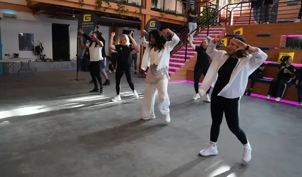 Group of people dancing in a brightly lit studio during a LES MILLS Dance class