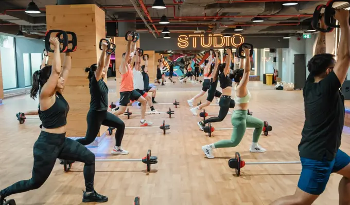GN-Group of people doing Les Mills BODYPUMP class at GymNation Dubai, using barbells and SMARTBAR equipment